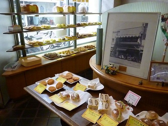 広島市の「ルーエぶらじる」の店内。現在はベーカリーカフェとしても人気だ。奥の額縁写真は、1956年に撮影された当時の外観で「モーニング」の文字が写っている