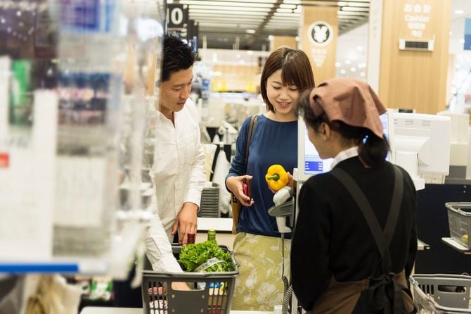 スーパーマーケットのレジカウンターで清算中のカップル