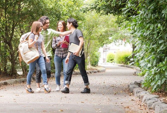 友人と歩く大学生のグループ