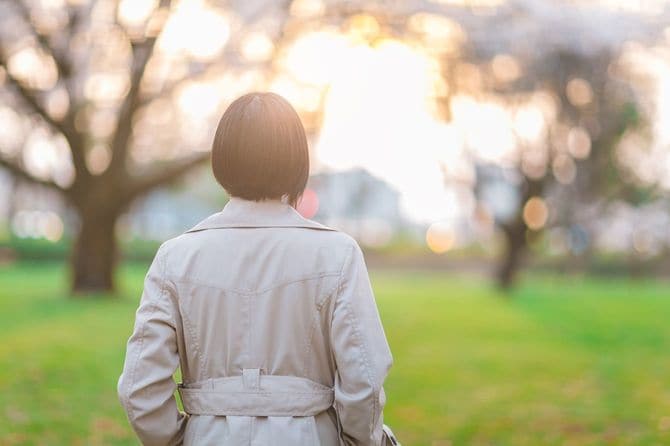 日没の公園に立つ女性