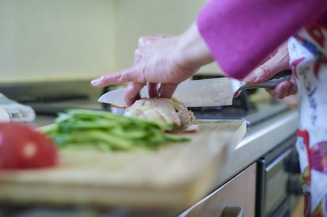 まな板の上で食材を切る人