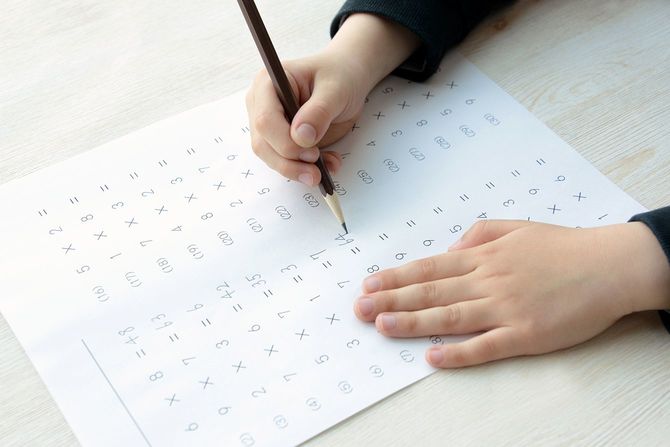 教育の概念、彼の机の上で一生懸命勉強している少年