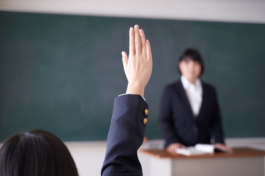 授業中に挙手をする女子生徒