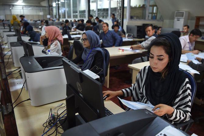アフガン大統領選の開票作業をする男女