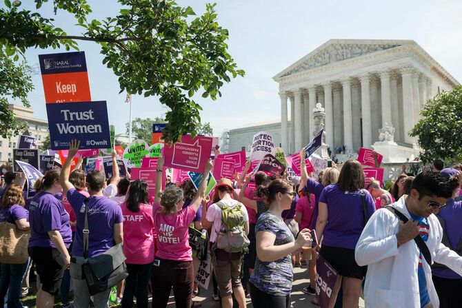 2016年6月27日、ワシントンD.C.で女性の中絶の権利を求める人々が集まり、メッセージを掲げている