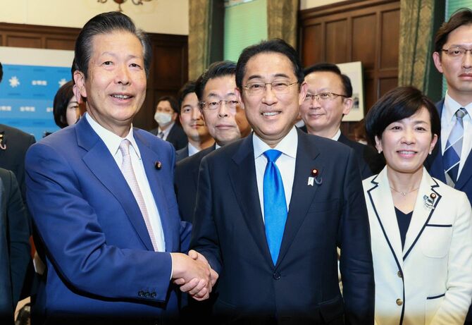 2023年度予算が成立後、公明党の山口那津男代表（左）と握手する岸田文雄首相（中央）＝2023年3月28日、国会内