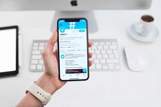 Twitterのページが表示されたスマホを持つ手