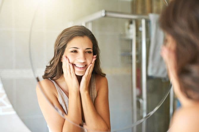 鏡を見て喜ぶ若い女性