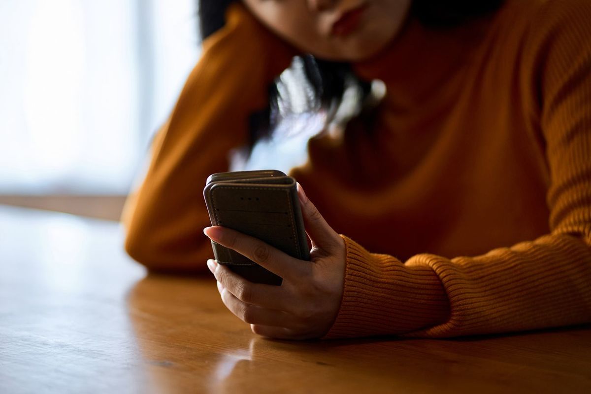 スマホを見てイライラする女性