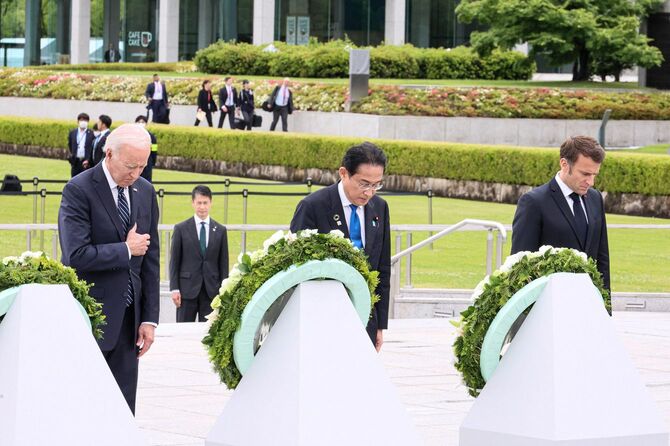 2023年5月19日、広島で開催されたG7首脳会議の一環として平和記念公園を訪問し、花輪を捧げた後、黙祷をする（左から右）ジョー・バイデン米国大統領、岸田文雄日本国首相、エマニュエル・マクロン仏大統領の様子が外務省により撮影・公開された。