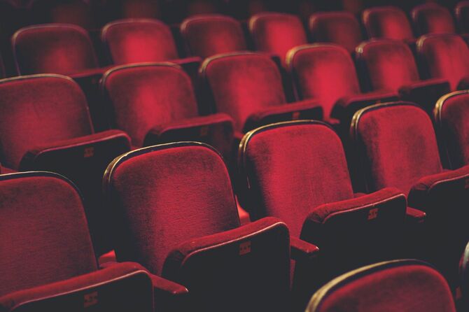 空席になった劇場の赤い椅子
