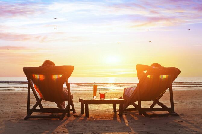 ビーチで豪華な夕陽を楽しむ幸せなカップル