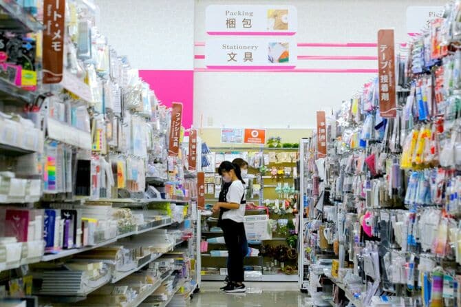 2022年8月30日、東京の100円ショップダイソーで、新型コロナの感染予防のためにフェイスマスクを着用して買い物をする人々