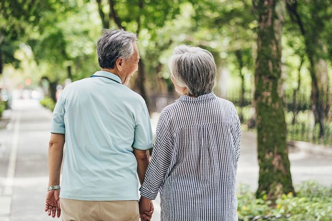 手をつないで歩くシニアカップル