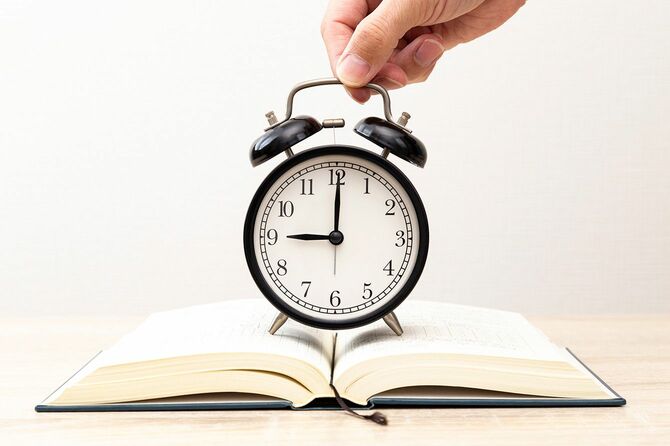 開いた本の上に時計を置く