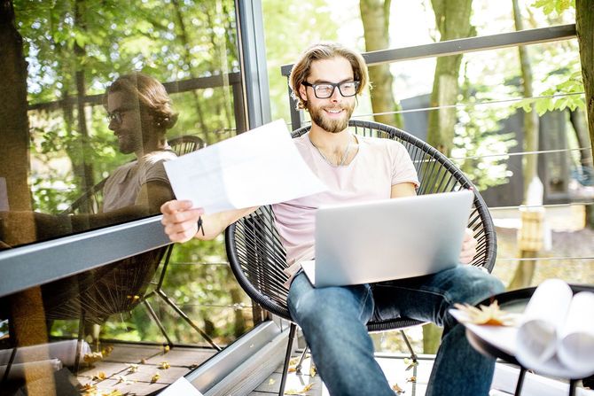 創造的な男が森の家で屋外での作業