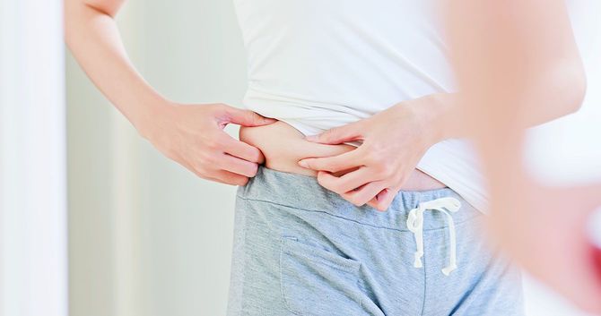 おなかの肉をつまむ人