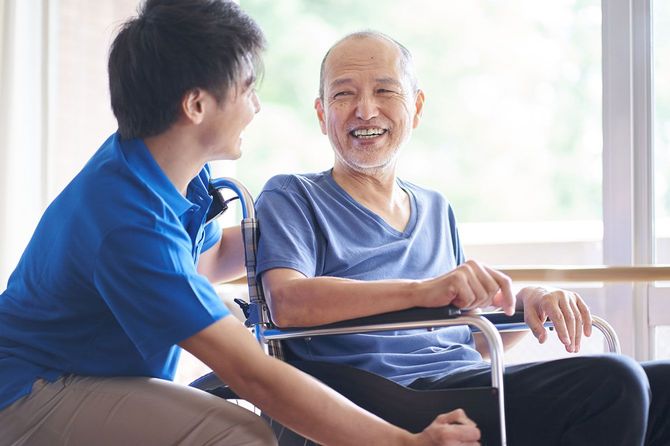 車椅子に乗る高齢者と介護者