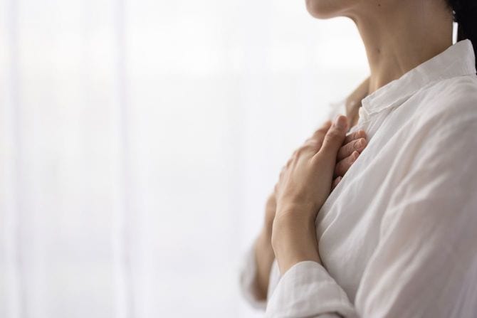 胸に手を当てる女性