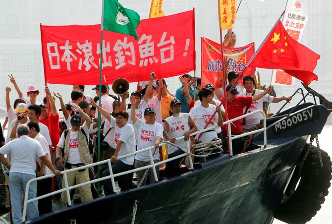 2006年10月22日、香港の船上でスローガンを叫び、中国の国旗を振る活動家たち。横断幕には「日本は釣魚島から出て行け」と書かれている。