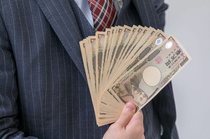 20万円ほどの紙幣をこちらに見せている男性の手元