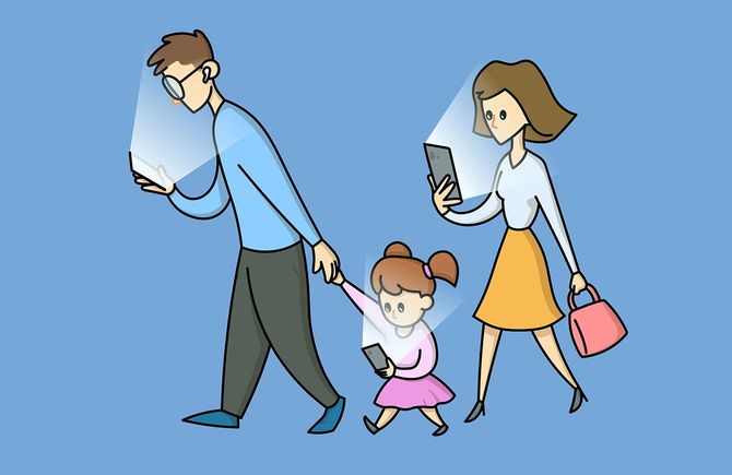 自分の携帯電話を見つめる3人の家族