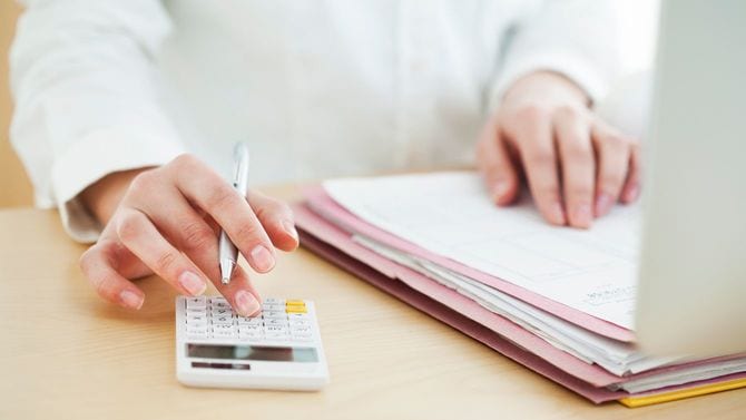 電卓を使用する女性の手元