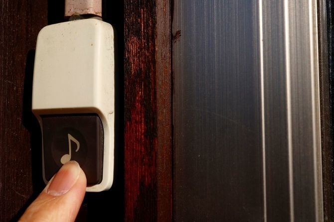 呼び鈴を押す手元