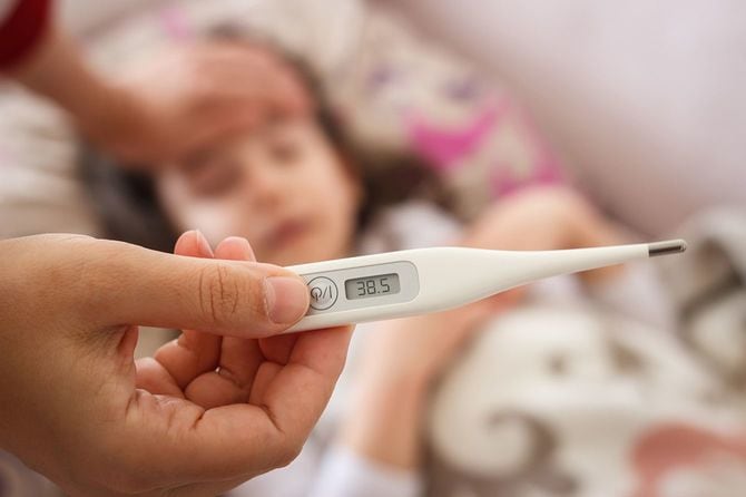 娘の熱を体温計で測る親