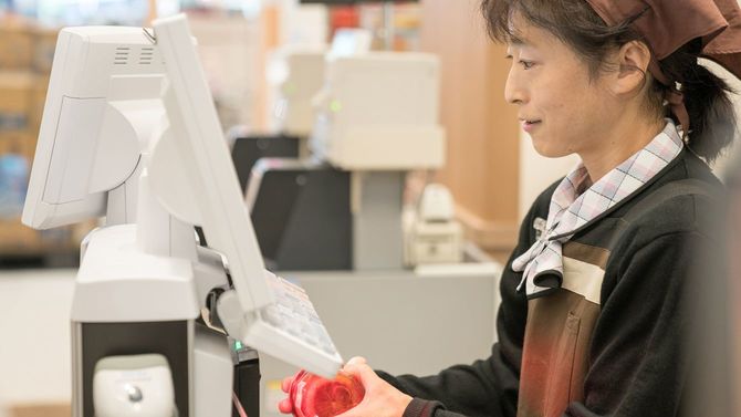 スーパーの店員がレジを使用している