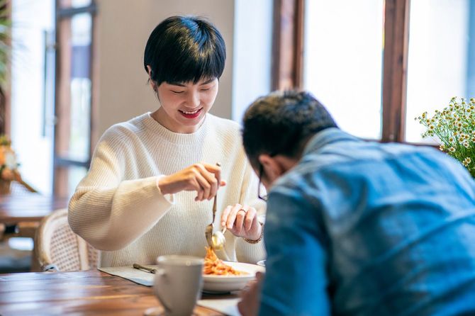 レストランでパスタを食べる若いカップル