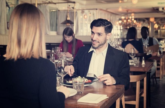 レストランで一緒に食事をしているカップル