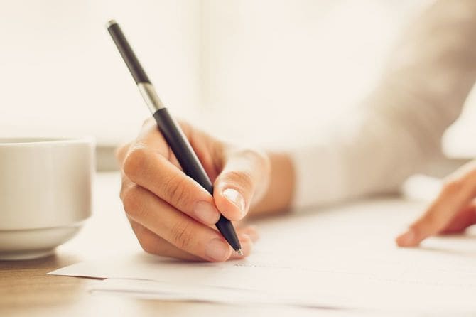 オフィスで紙に書く実業家の手