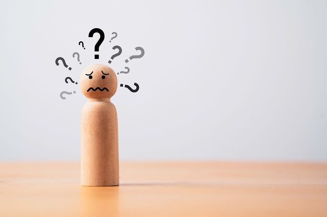 多くのハテナマークを持つ木製の人形