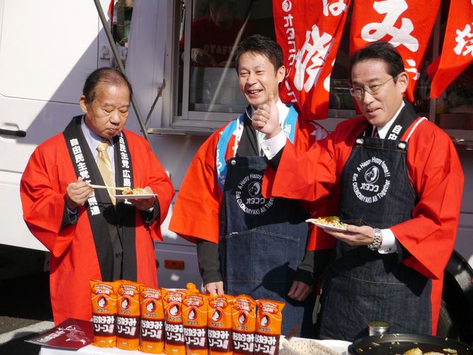 物産展「がんばろう広島」で、お好み焼きを振る舞う自民党の岸田文雄政調会長(右)と試食する二階俊博幹事長(左)=2019年1月23日、東京・永田町の同党本部