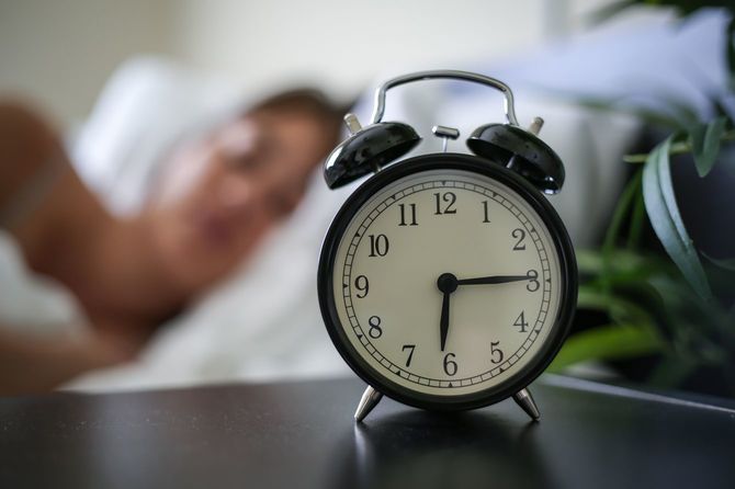 ベッドわきの目覚まし時計は6時15分を指している