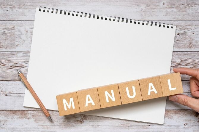 「MANUAL」木製のブロック、ペン、ノートブック