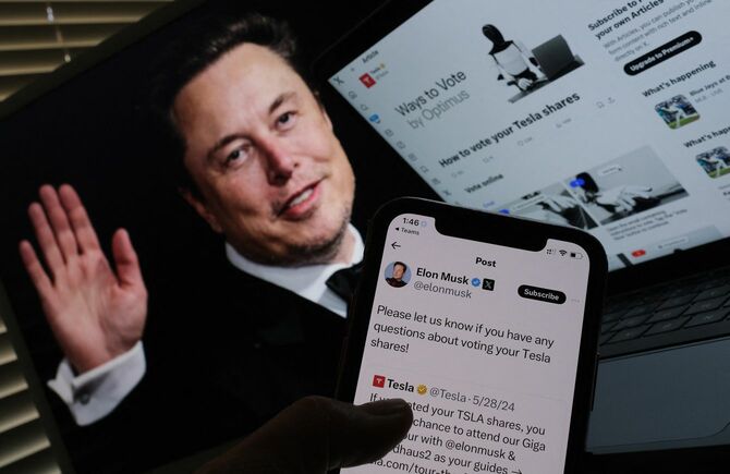 2024年6月12日、テスラ株主総会を前にXで開始された南アフリカ人実業家イーロン・マスクのキャンペーンが映し出されたスクリーンの前で(ロサンゼルス)