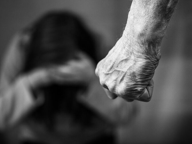 女性に対する家庭内暴力の男は拳の黒と白のイメージを握りしめた