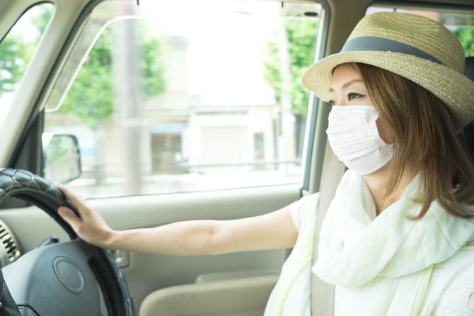 マスクを着用して自家用車を運転する日本人女性