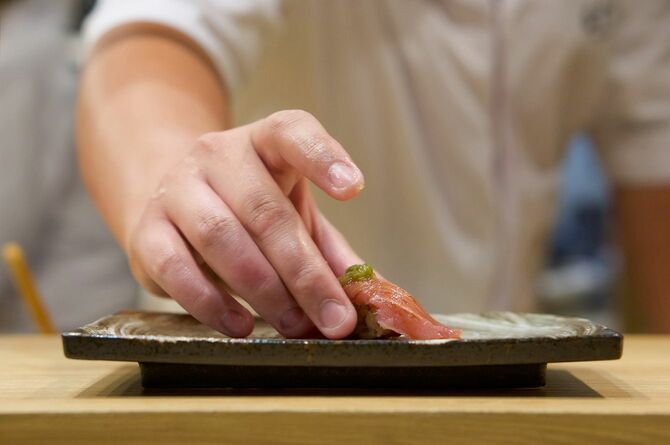 寿司を客に出す寿司職人の手元