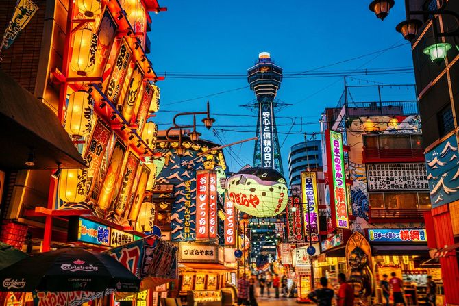 大阪タワーが見える、ネオンや広告があふれる新世界の街並み