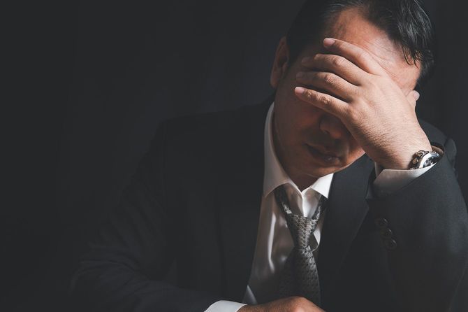 頭を抱えている男性