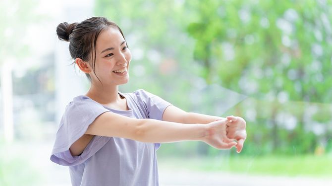 リビングルームで伸びる魅力的な日本人女性