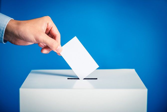 投票箱に用紙を入れる手