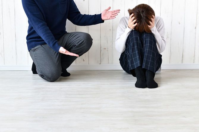 頭を押さえたまま女性に文句を言う男性