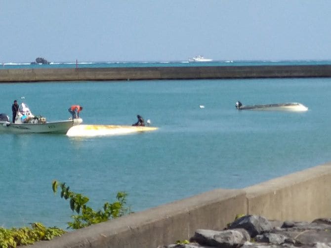 辺野古沖で船2隻が転覆し船長と研修旅行中の生徒が死亡した事故で、岸壁近くまで曳航された2隻の船=2026年3月16日、沖縄県名護市の辺野古漁港