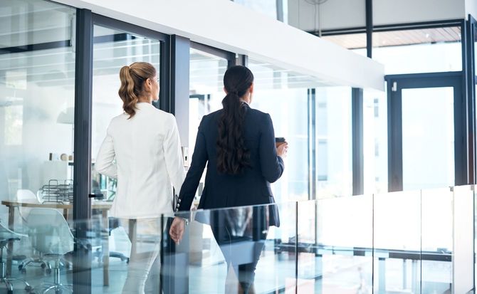 オフィスで一緒に歩く2人のビジネスウーマン