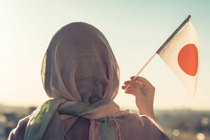 日本国旗を持つイスラム教徒の女性