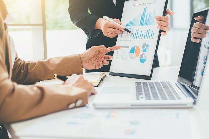 資料を見ながら話し合う2人のビジネスマン